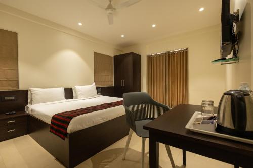 a hotel room with a bed and a desk at Freesia Residency by Express Inn in Nashik