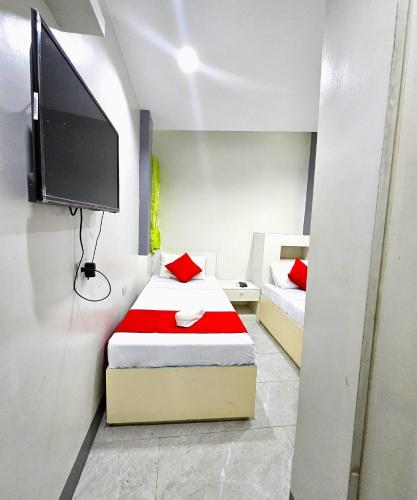 a bedroom with two beds and a flat screen tv at JRJA Suites 1 near Card Bank Tagum in Tagum