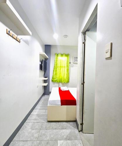 a room with a bed with a green window at JRJA Suites 1 near Card Bank Tagum in Tagum