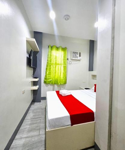 a bedroom with a bed with a red and white blanket at JRJA Suites 1 near Card Bank Tagum in Tagum