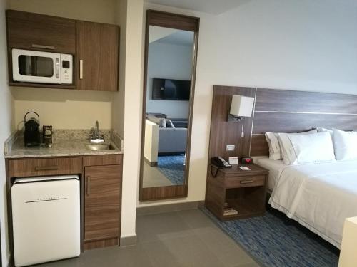 a hotel room with a bed and a microwave at Holiday Inn Express & Suites - Ciudad Obregon by IHG in Ciudad Obregón