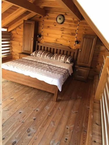 um quarto com uma cama num chalé de madeira em Vila Djekic em Andrijevica