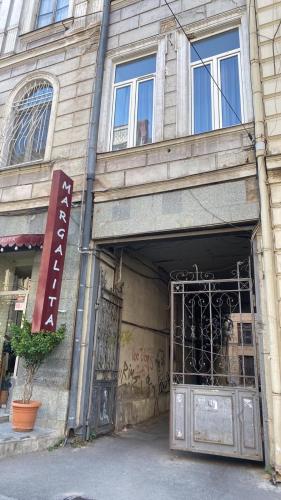 una entrada a un edificio con un cartel en él en Cozy apartment in the center, en Tiflis