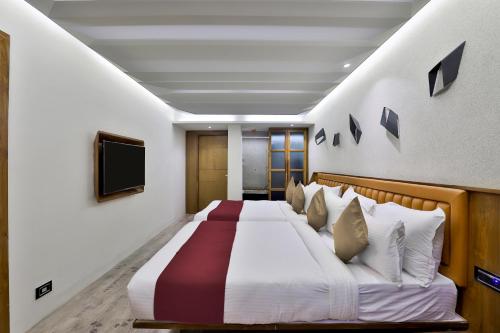 a bedroom with a large bed with a television on the wall at Keys Select by Lemon Tree Hotels, Gandhi Ashram, Ahmedabad in Ahmedabad