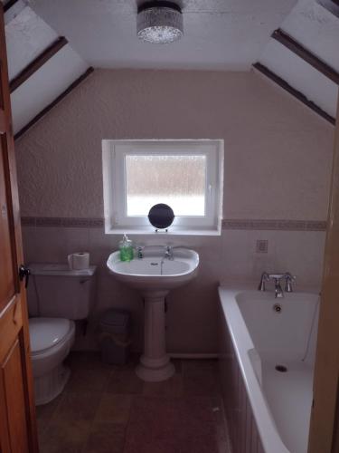 BarmstonにあるFisherman's cottageのバスルーム(洗面台、トイレ付)、窓が備わります。