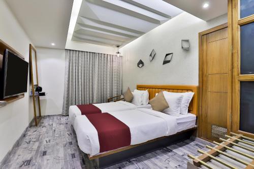 a hotel room with a bed and a tv at Keys Select by Lemon Tree Hotels, Gandhi Ashram, Ahmedabad in Ahmedabad