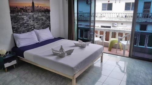 a bedroom with a bed and a balcony with a view at The Guest House in Patong Beach