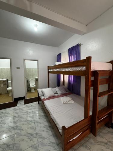 a bedroom with two bunk beds and a bathroom at Mario's White House in Langi-langiban
