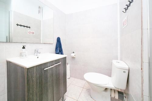 Baño blanco con aseo y lavamanos en Fabrizzios Terrace Hostel, en Barcelona