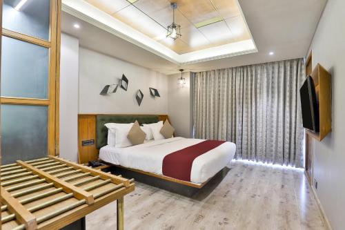 a hotel room with a bed and a tv at Keys Select by Lemon Tree Hotels, Gandhi Ashram, Ahmedabad in Ahmedabad