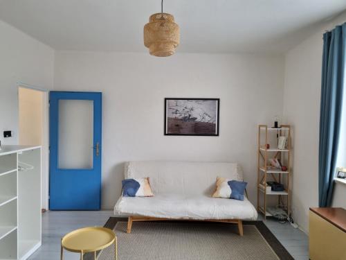 uma sala de estar com um sofá branco e uma porta azul em Rodinný apartmán Výrov em Nové Město nad Metují