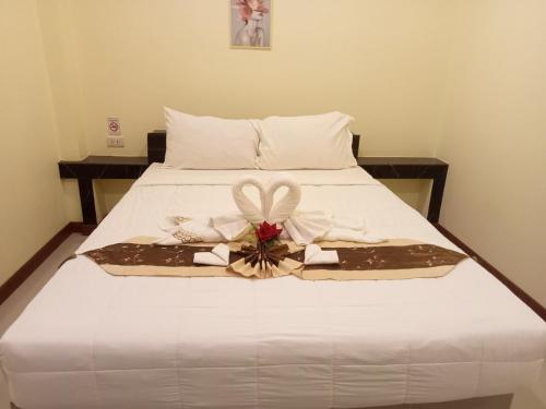 Una cama blanca con un arco encima. en ไลอ้อน โฮเทล, en Chumphon