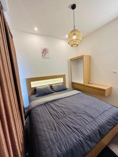 - une chambre avec un lit et un lustre dans l'établissement Eleven villa 1, à Pangandaran