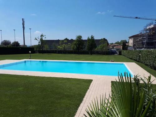 a large blue swimming pool in a field of grass at Caba Holiday Bardolino Pasubio in Bardolino