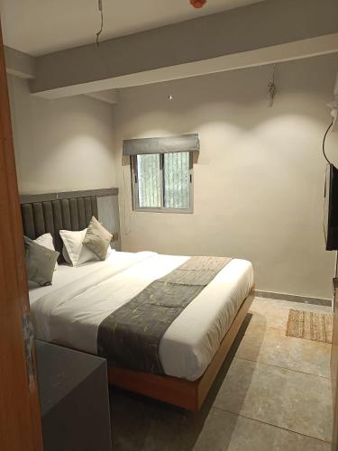 - une chambre avec un grand lit et une fenêtre dans l'établissement Relax Inn - Drive In Road, à Ahmedabad