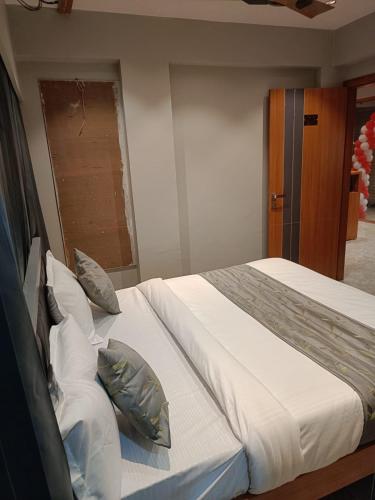 een slaapkamer met een groot bed met kussens bij Relax Inn - Drive In Road in Ahmedabad