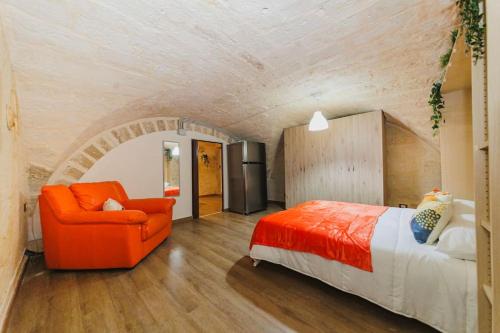 a bedroom with an orange chair and a bed at Loft 21 - Lungomare Barium in Bari
