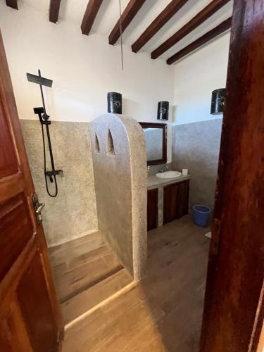 彭圭的住宿－Malcom Residence，浴室配有水槽和墙壁上的十字架