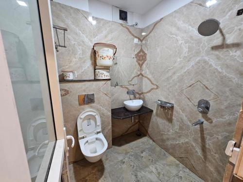 a bathroom with a toilet and a sink at Hotel Aditya Inn in Varanasi