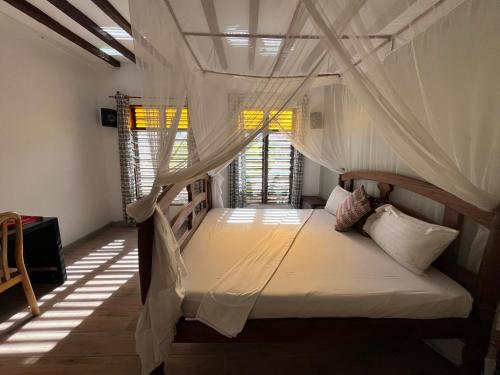 sypialnia z 2 łóżkami piętrowymi i moskitierami w obiekcie Malcom Residence w mieście Pongwe