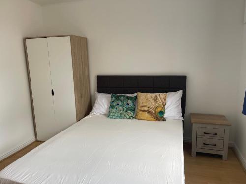 a bedroom with a white bed with two pillows at 2Bed Cozy Spacious apartment - 15min to Canary Wharf O2 Excel Central London in London