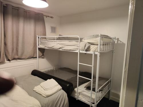 a room with two bunk beds and a bed at home from home in Erith