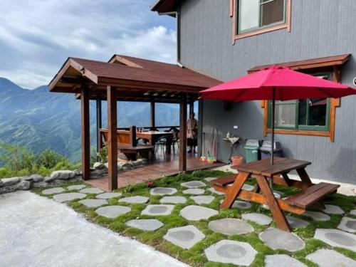 a patio with a picnic table and an umbrella at Shiyai Taoyuan in Renai