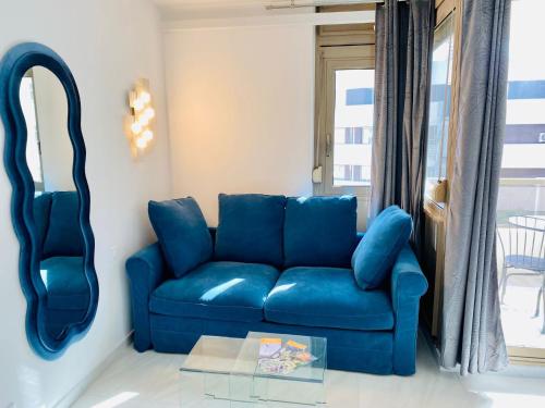 a blue couch in a living room with a mirror at Résidence Graziella appartement 410 in Juan-les-Pins