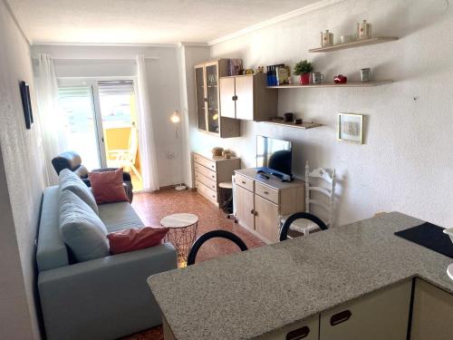 cocina y sala de estar con sofá y mesa en High-Floor Bright Apartment with Sea Views, en Mareny Blau