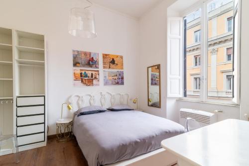 a white bedroom with a bed and a window at Luxury apartment near via veneto in Rome