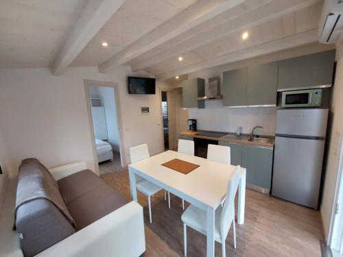 ein Wohnzimmer mit einem Sofa und einem Tisch sowie eine Küche in der Unterkunft Camping Le Maior in Brenzone sul Garda