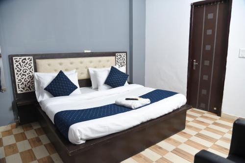 1 dormitorio con 1 cama con almohadas azules y blancas en Hotel Orchid INN at Budget Bazaar Janakpuri en Nueva Delhi