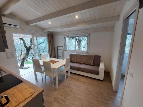 een woonkamer met een tafel en een bank bij Camping Le Maior in Brenzone sul Garda