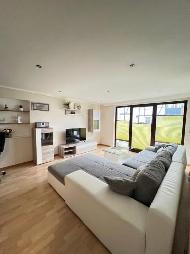 a large white bedroom with a large bed and a couch at Elpe in Olsberg