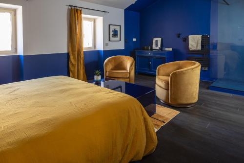 a bedroom with a large bed and two chairs at La Re-Source, propriété idéale pour séminaires et réunions in Alleins
