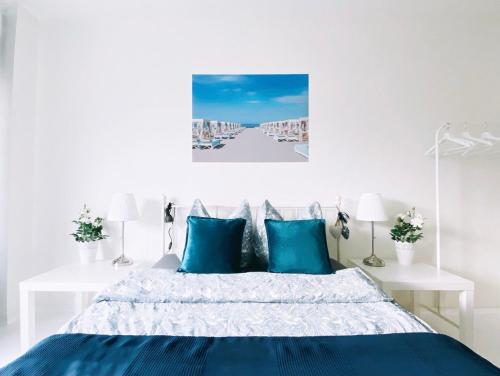 a white bedroom with a bed with blue pillows at Great central premium 1 BR apartment in best area 10117 Berlin Mitte, Leipziger Straße in Berlin