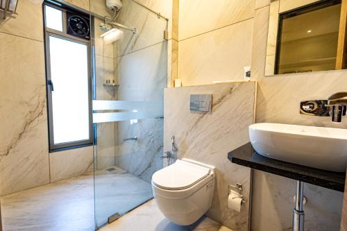 a bathroom with a toilet and a sink and a shower at Freesia Residency By Express Inn - Navi Mumbai in Navi Mumbai