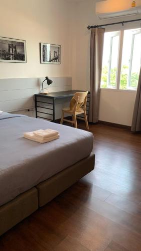 a bedroom with a desk and a bed and a chair at Jeboutiquelangsuan hotel in Lang Suan