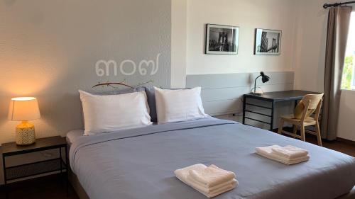a bedroom with a bed with two towels on it at Jeboutiquelangsuan hotel in Lang Suan