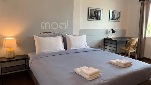 a bedroom with a bed with two towels on it at Jeboutiquelangsuan hotel in Lang Suan