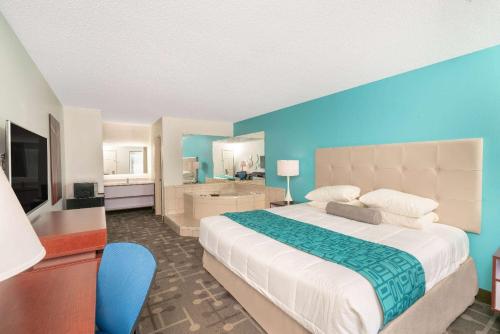 1 dormitorio con 1 cama grande y pared azul en Howard Johnson by Wyndham Aiken, en Aiken