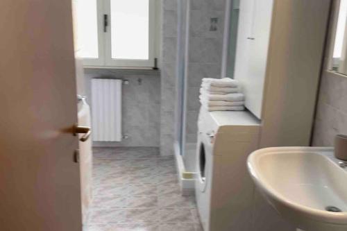 een badkamer met een wastafel, een toilet en een spiegel bij Appartamento centrale a Soverato in Soverato Marina