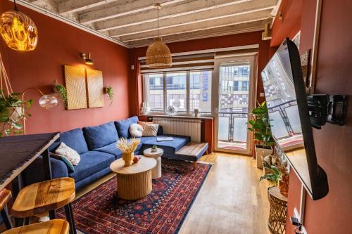 Cozy Central في بريشتيني: غرفة معيشة مع أريكة زرقاء وطاولة