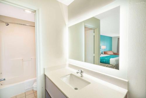 a white bathroom with a sink and a mirror at Howard Johnson by Wyndham Aiken in Aiken