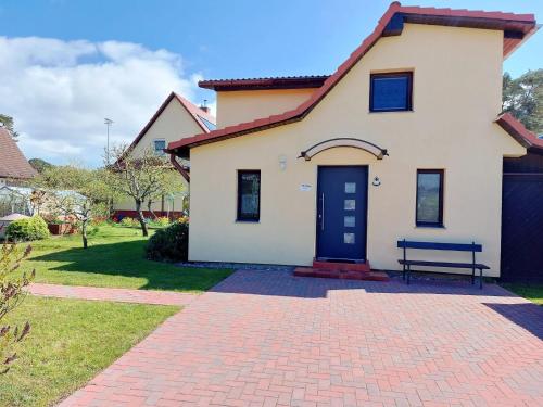 ルブミンにあるFerienhaus Seeadler DH-39518の煉瓦造りの私道の青い扉のある家