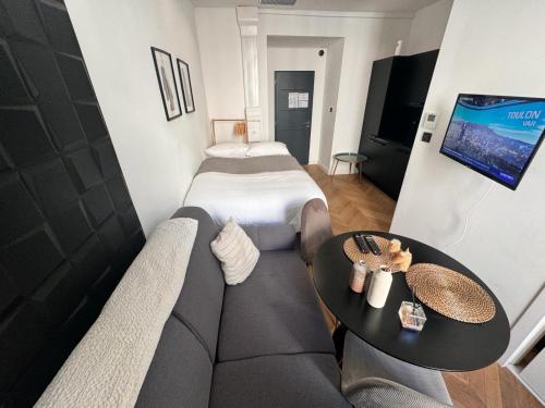 un salon avec un canapé et un lit dans l'établissement Chic Cozy Studio in the Heart of the City, à Nice