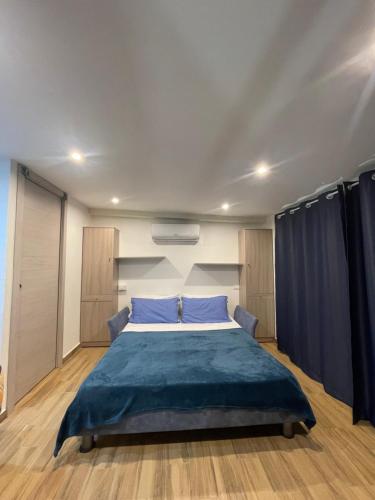 - une chambre dotée d'un grand lit avec des draps bleus dans l'établissement Taormina's sun apartment, à Taormine
