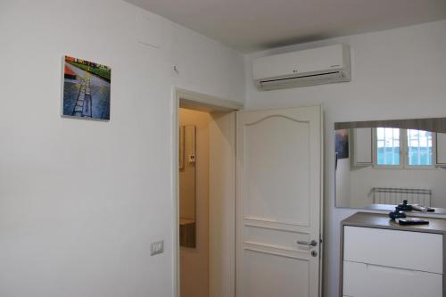 a kitchen with a white door and a refrigerator at Villa CasArte in Bari