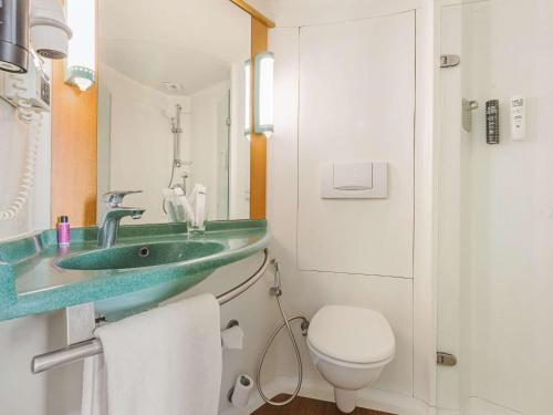 ein Badezimmer mit einem grünen Waschbecken und einem WC in der Unterkunft ibis Nashik - An Accor Brand in Nashik