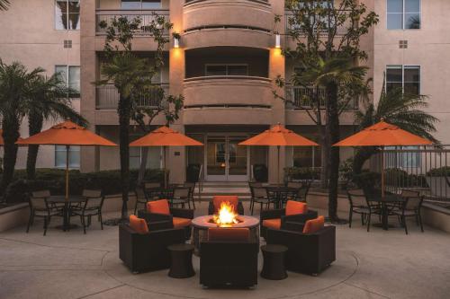 an outdoor patio with chairs and tables and umbrellas at Hyatt House Cypress / Anaheim in Cypress
